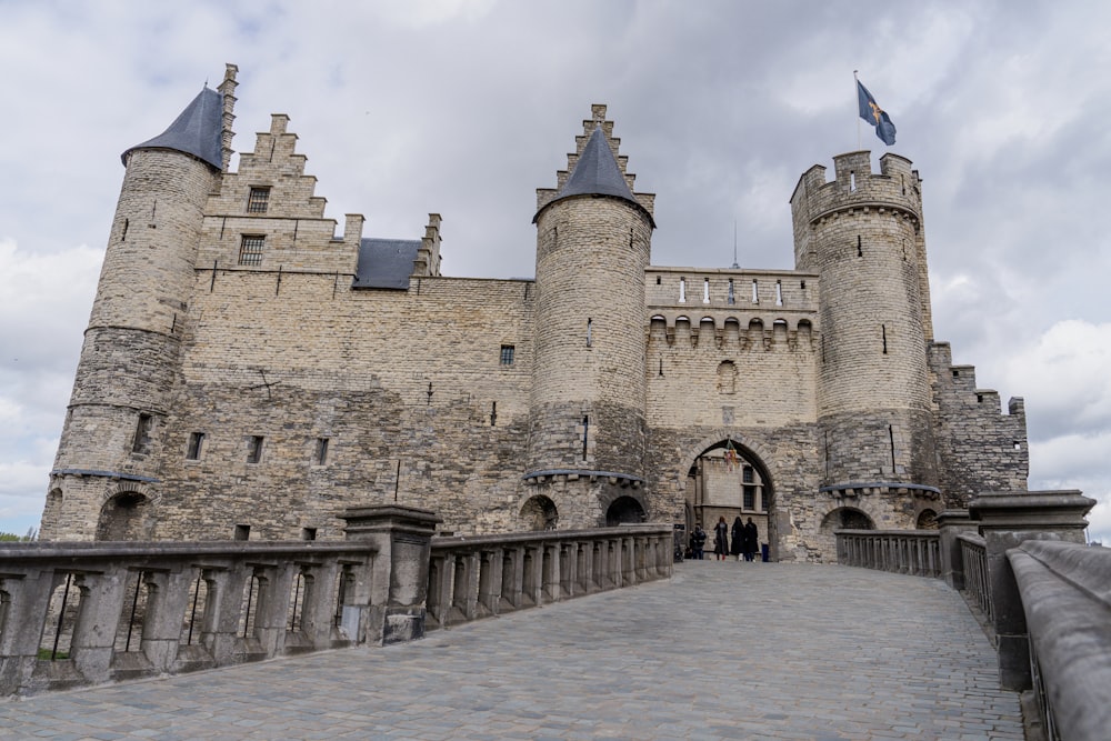 a stone castle with a walkway leading to it