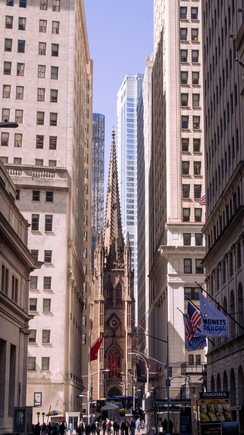 a group of people walking down a street next to tall buildings