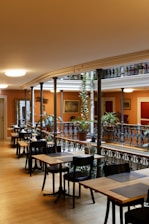 a restaurant with tables and chairs and a balcony