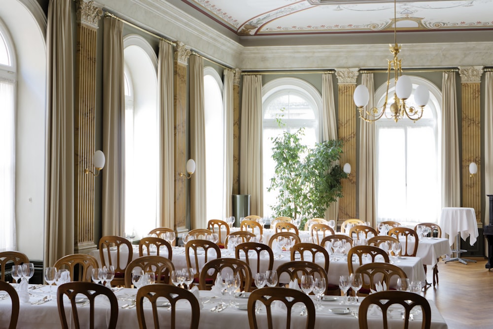 a dining room with tables, chairs, and a piano