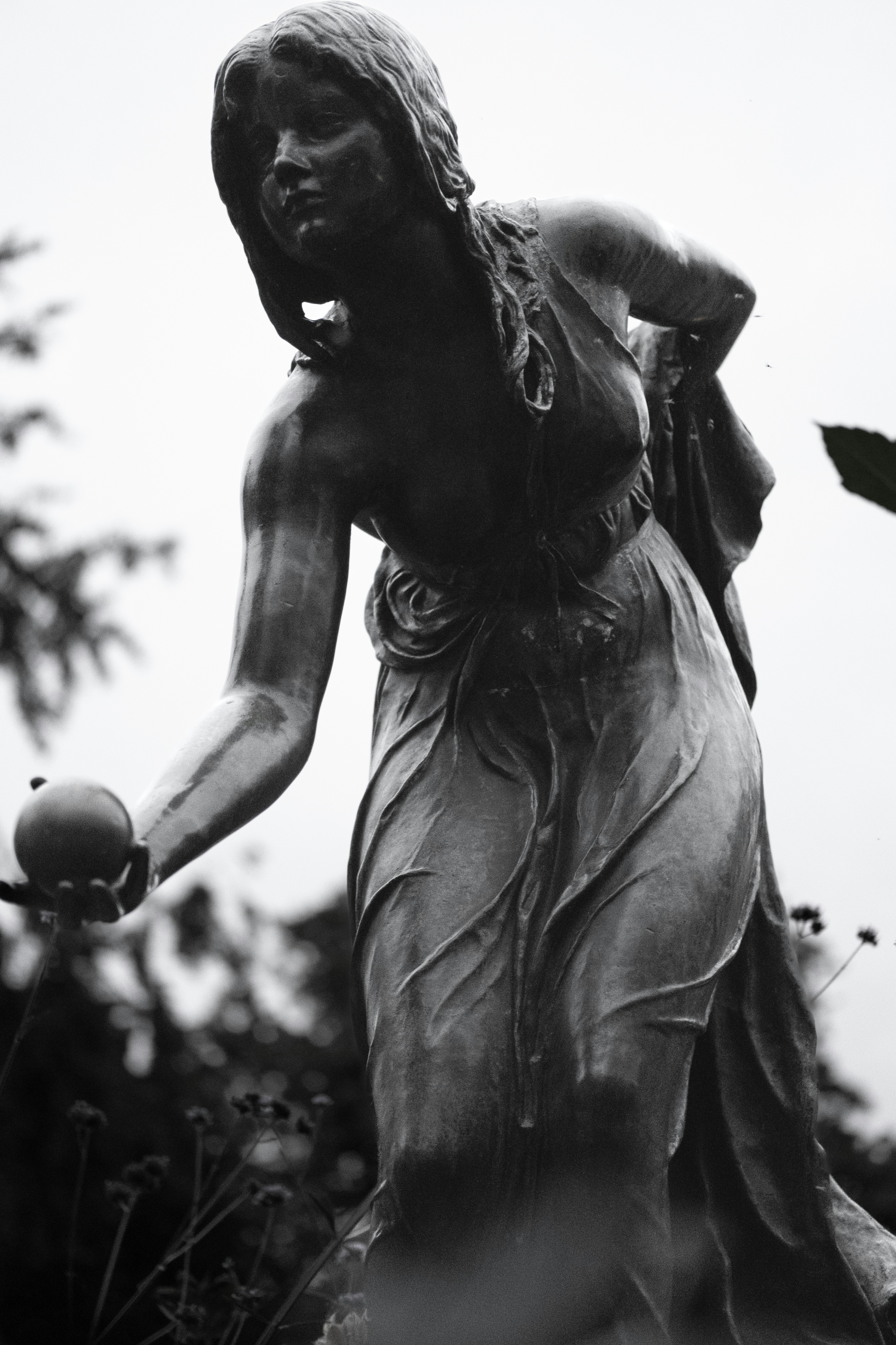 eine Statue einer Frau, die einen Apfel hält