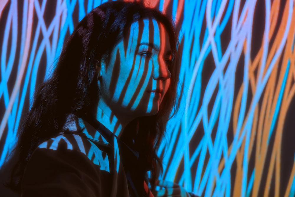 a woman standing in front of a colorful wall