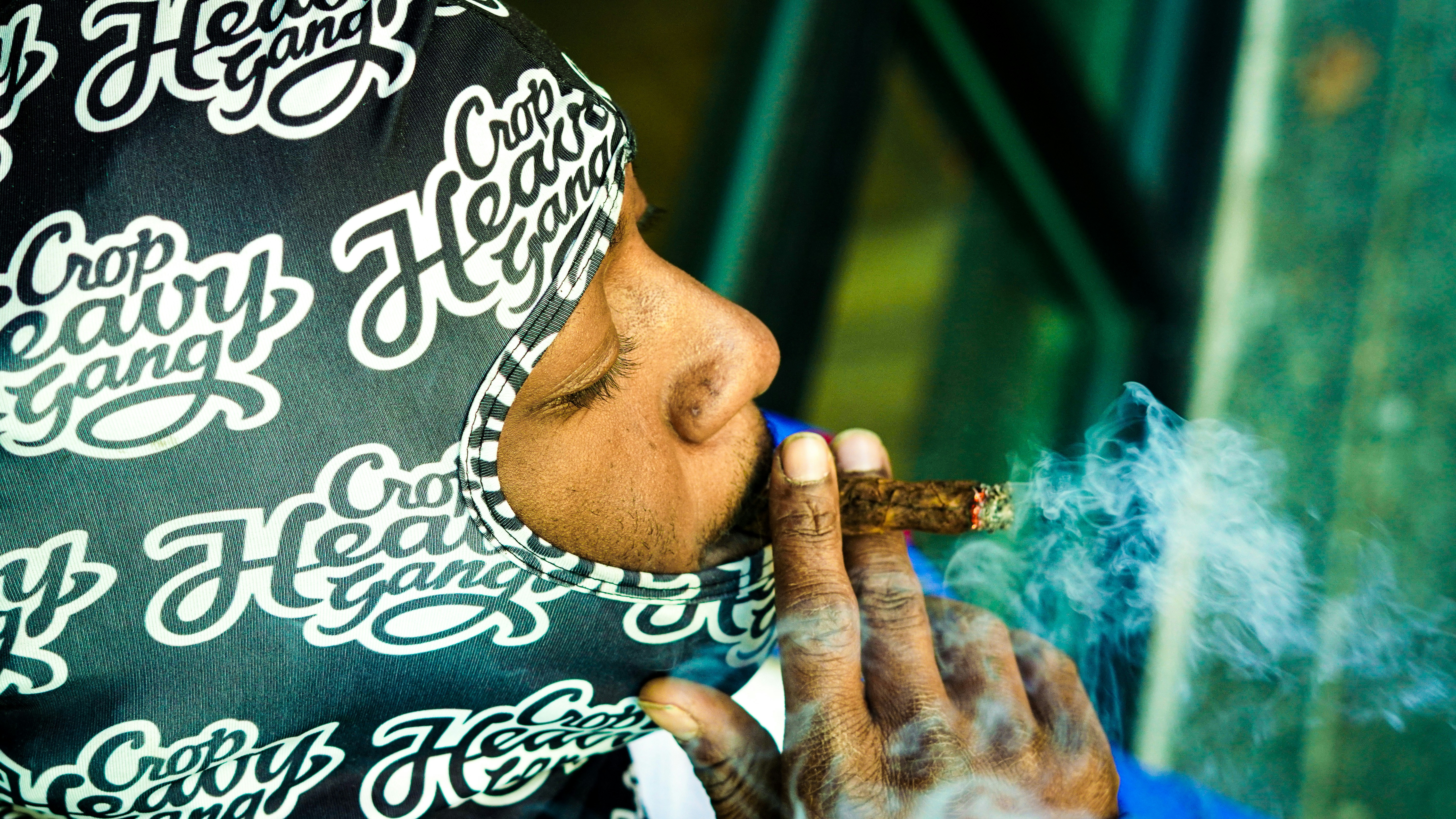 a man smoking a cigarette while wearing a bandana