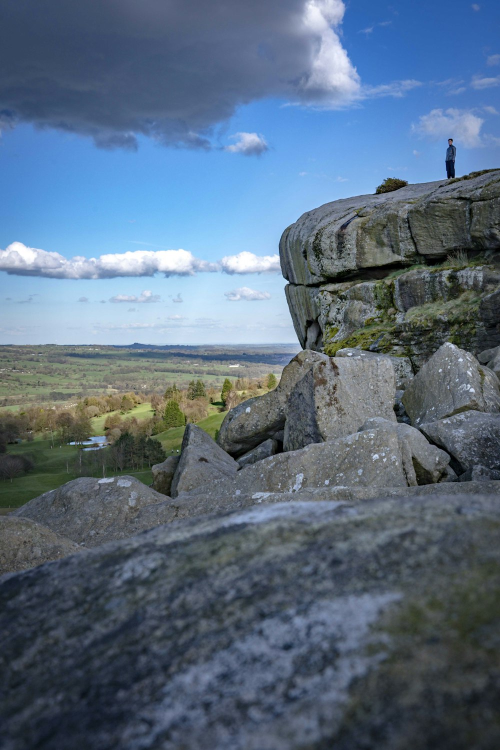 una persona in piedi in cima a una grande roccia