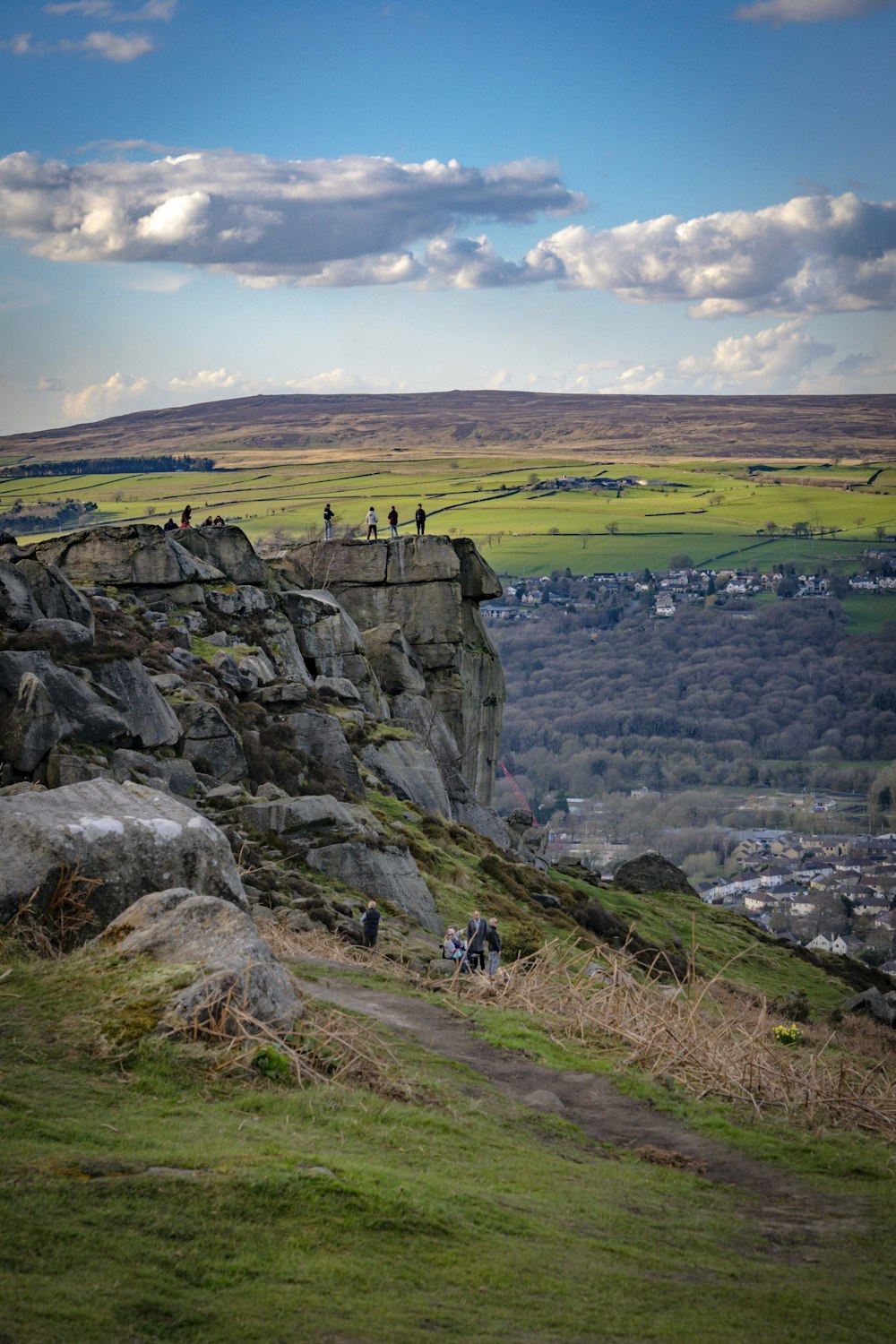 a group of people standing on top of a lush green hillside