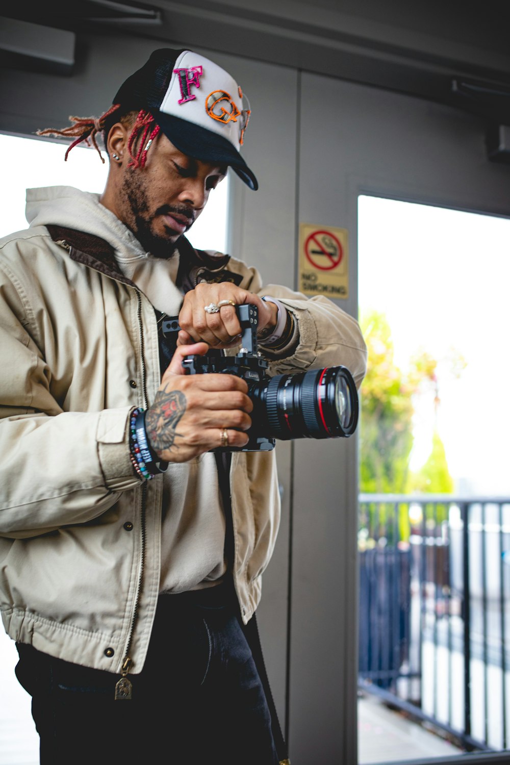 a man with dreadlocks holding a camera