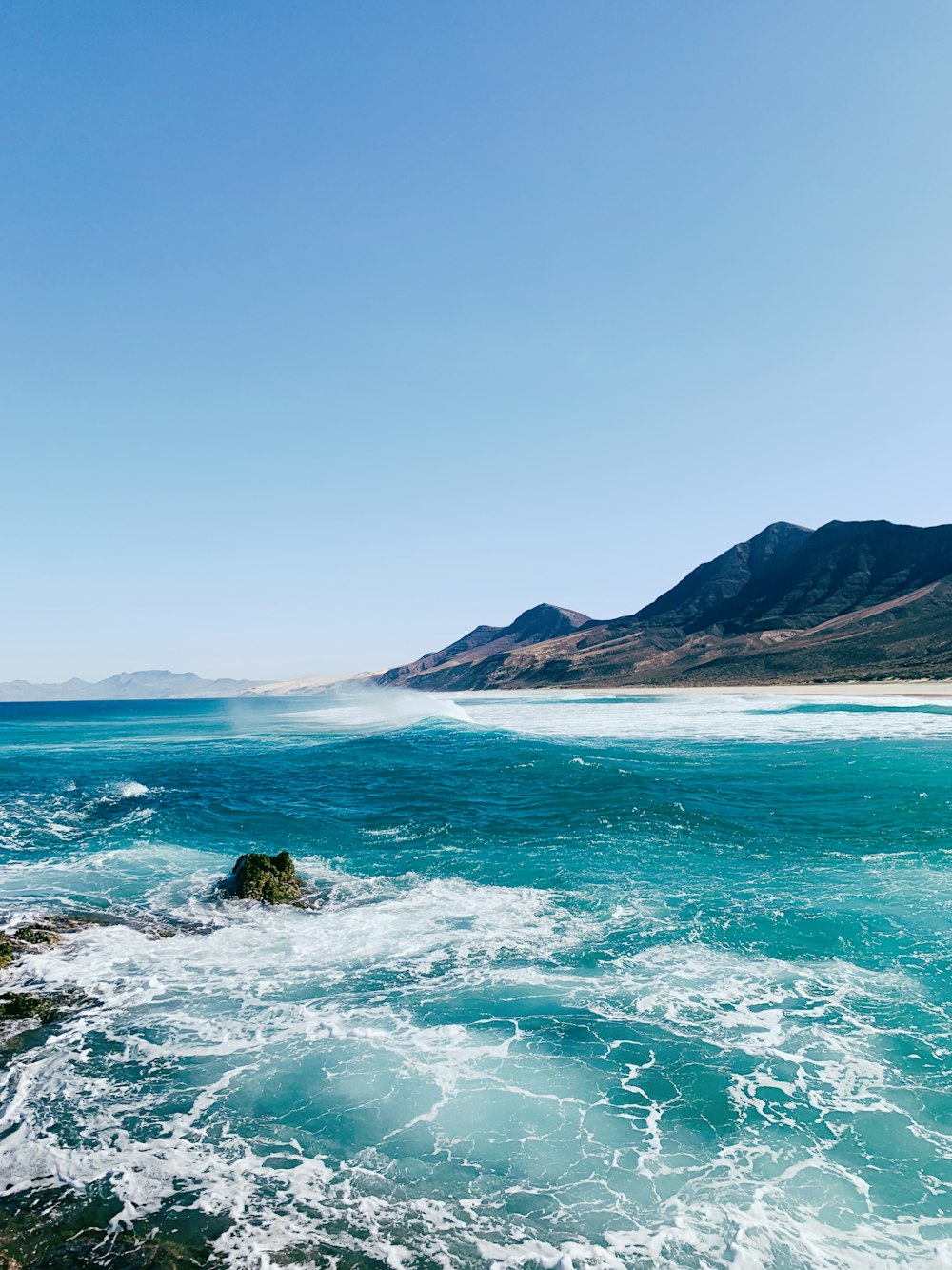 a body of water with mountains in the background