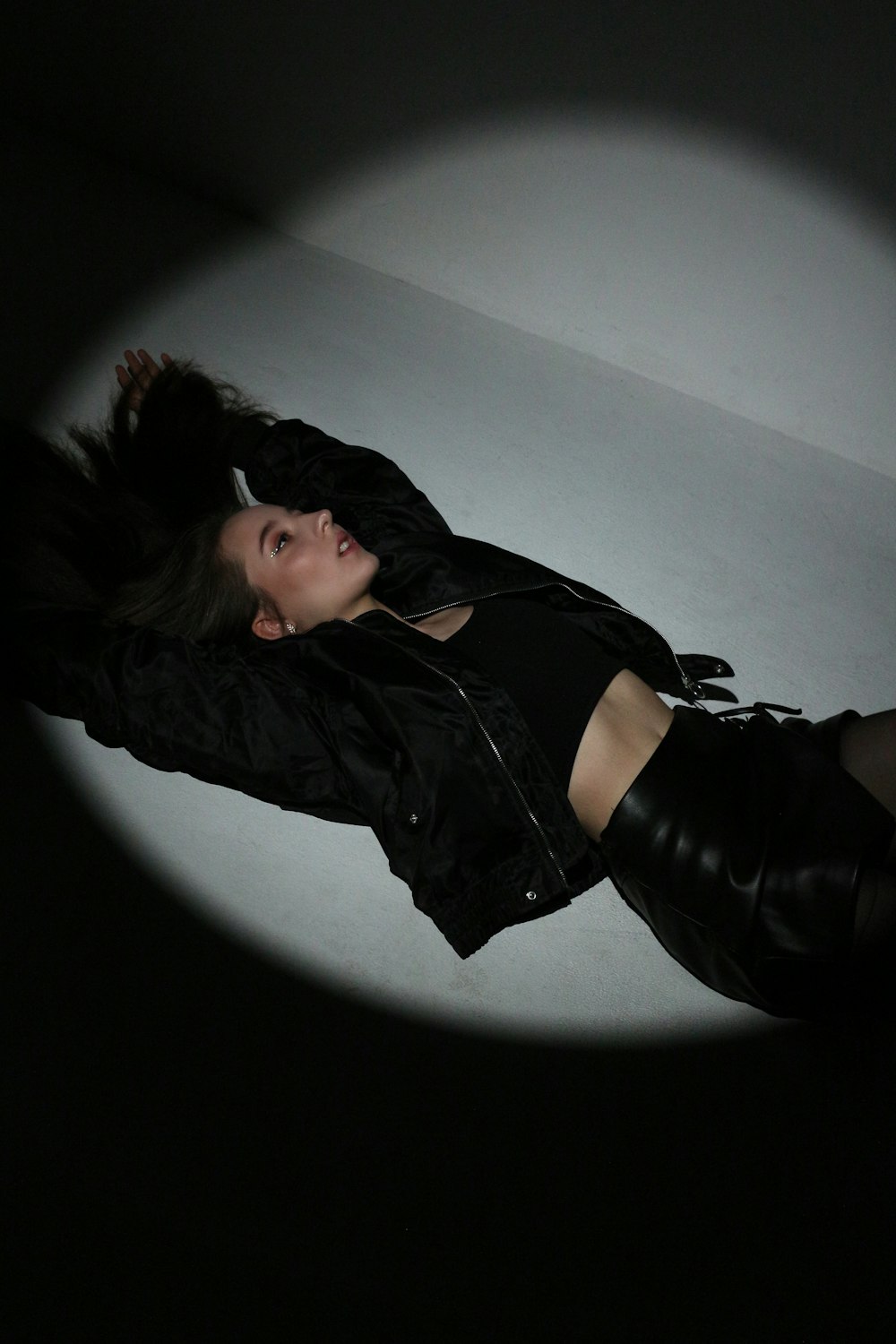 a woman laying on the floor in a dark room