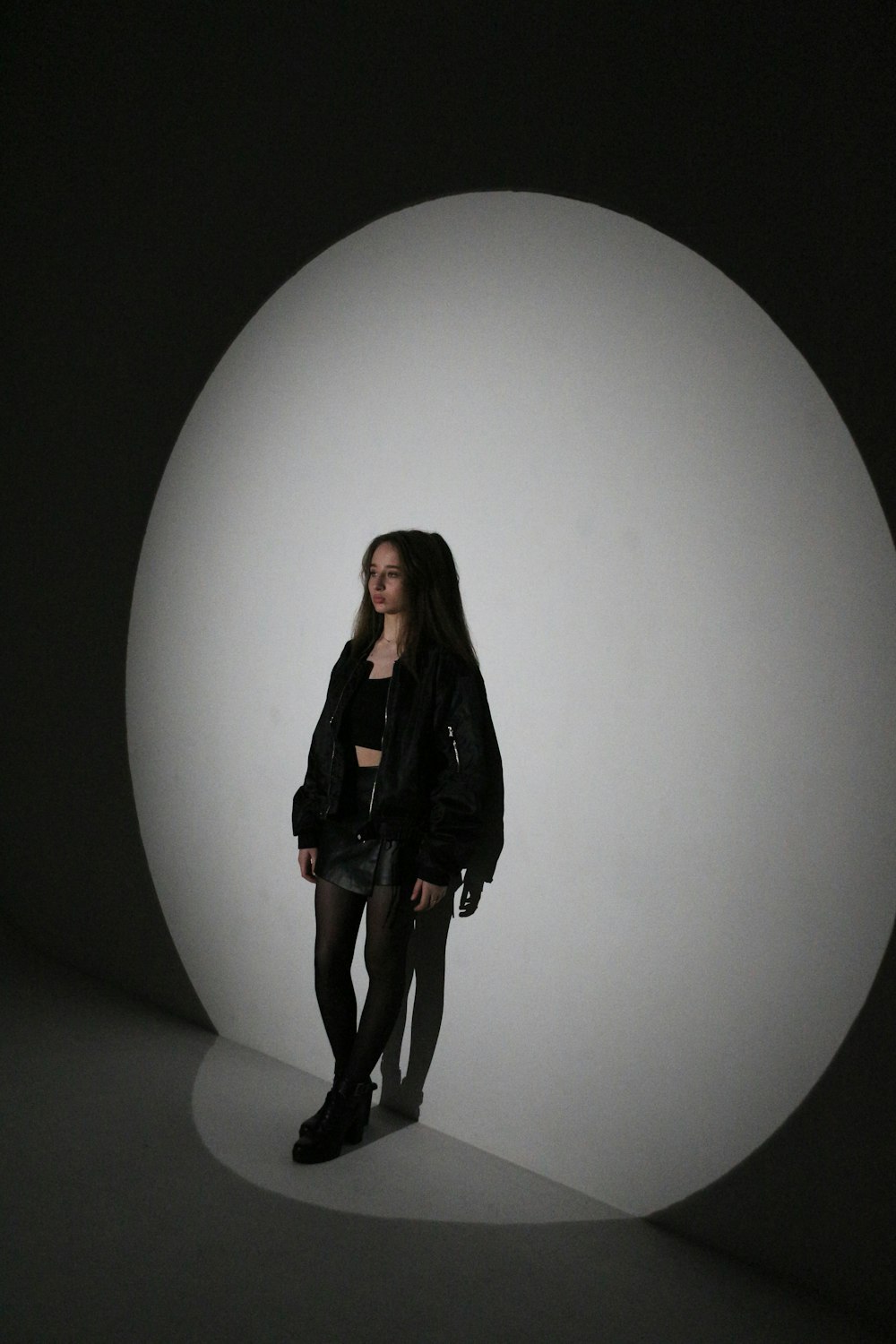 a woman standing in front of a white ball