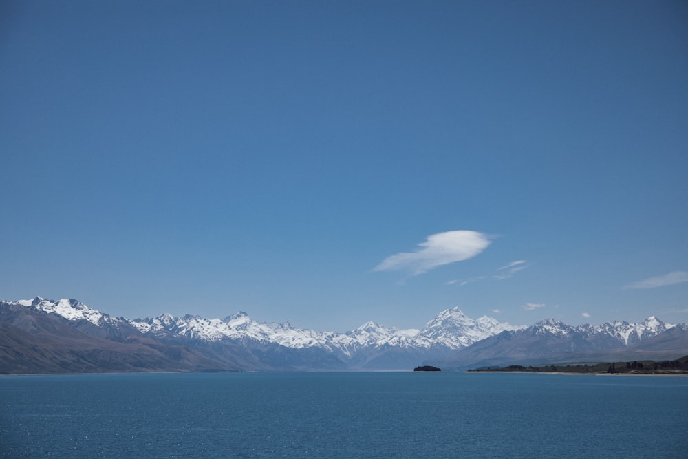 a large body of water with mountains in the background