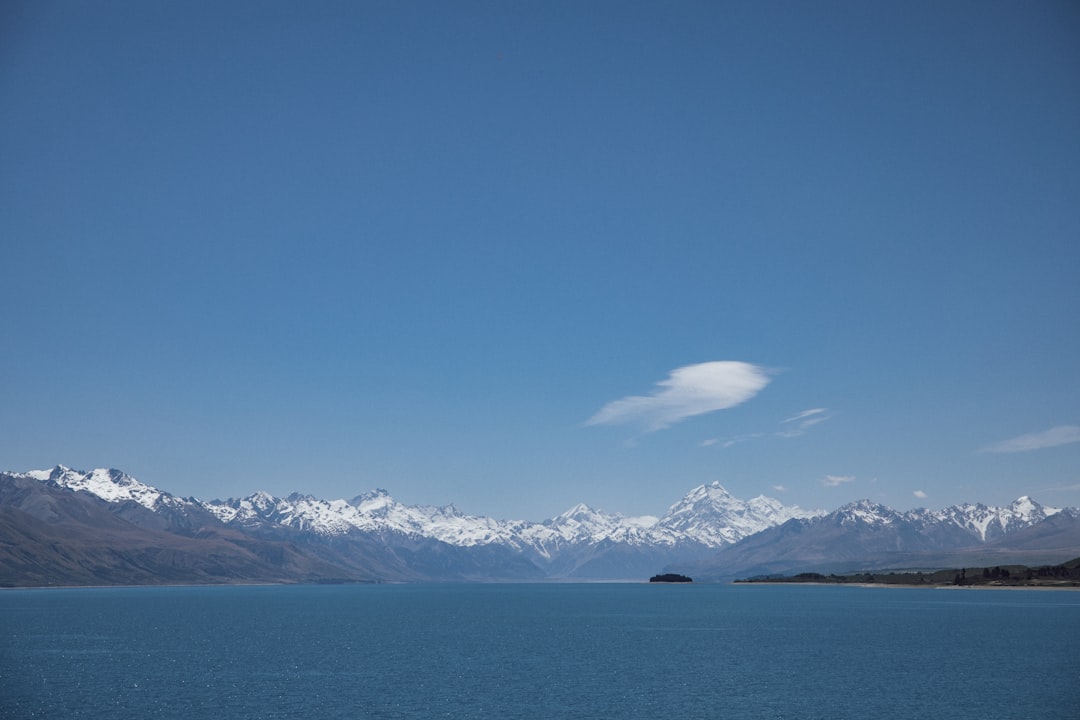 a large body of water with mountains in the background,