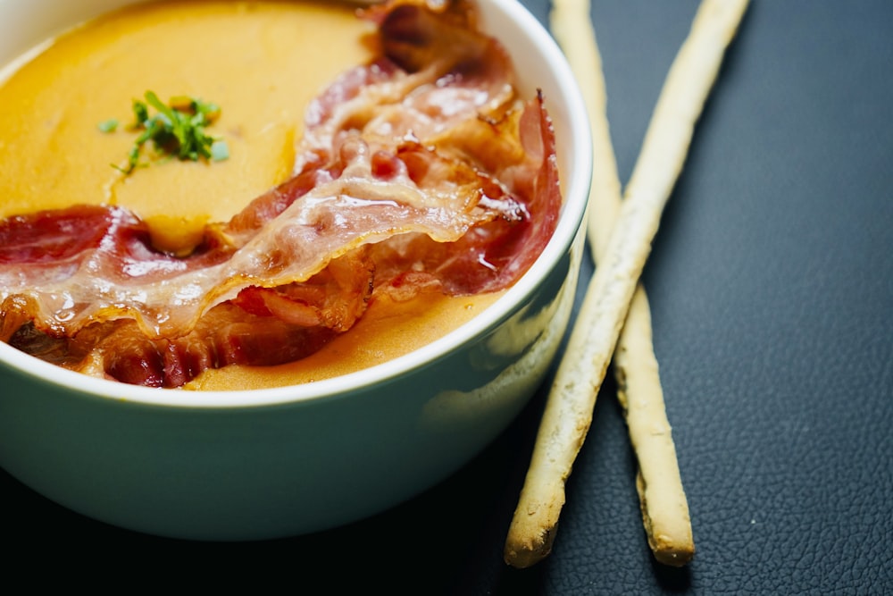 a close up of a bowl of soup with bacon