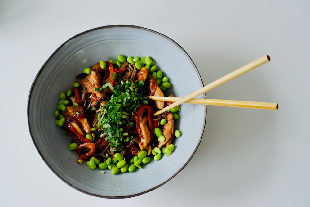 a bowl of food with chopsticks in it