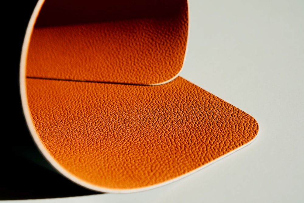 a close up of an orange object on a white surface
