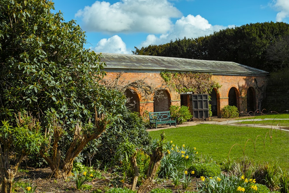 a brick building with a green bench in the middle of it