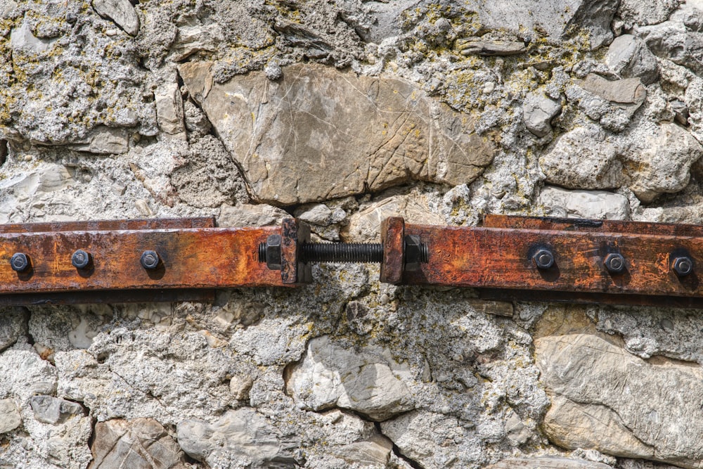 a rusted metal handle on a stone wall