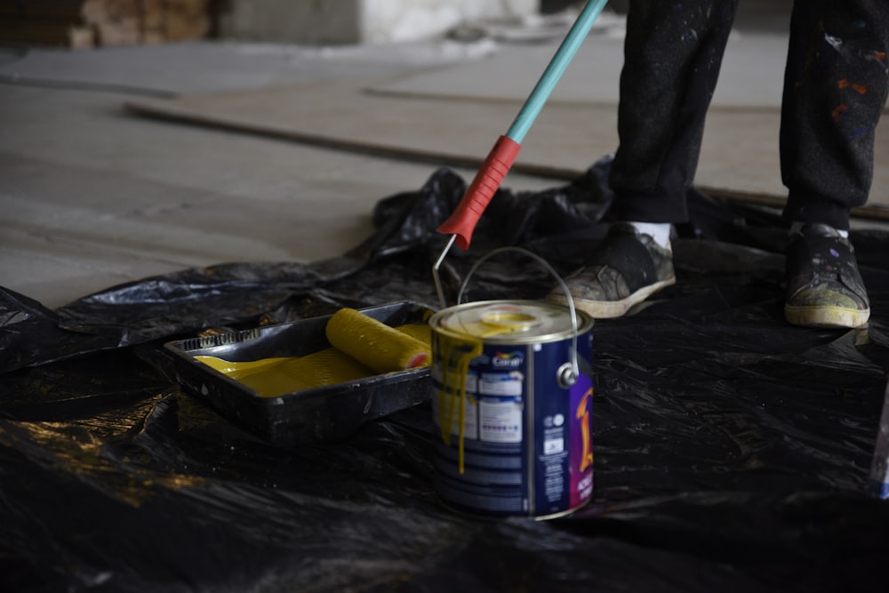 a person with a mop and a can of paint