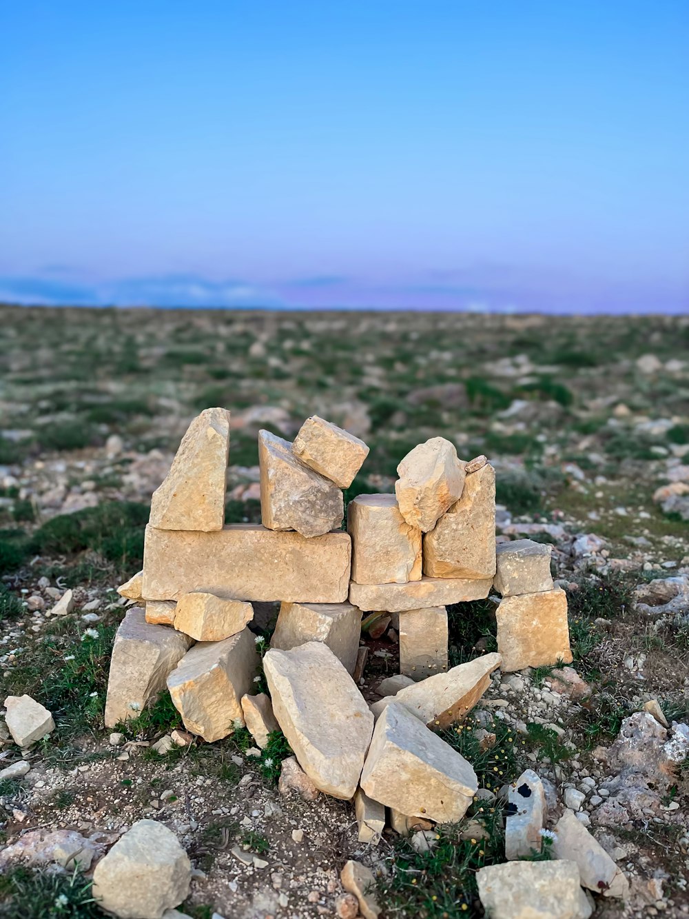 a pile of rocks sitting on top of a grass covered field