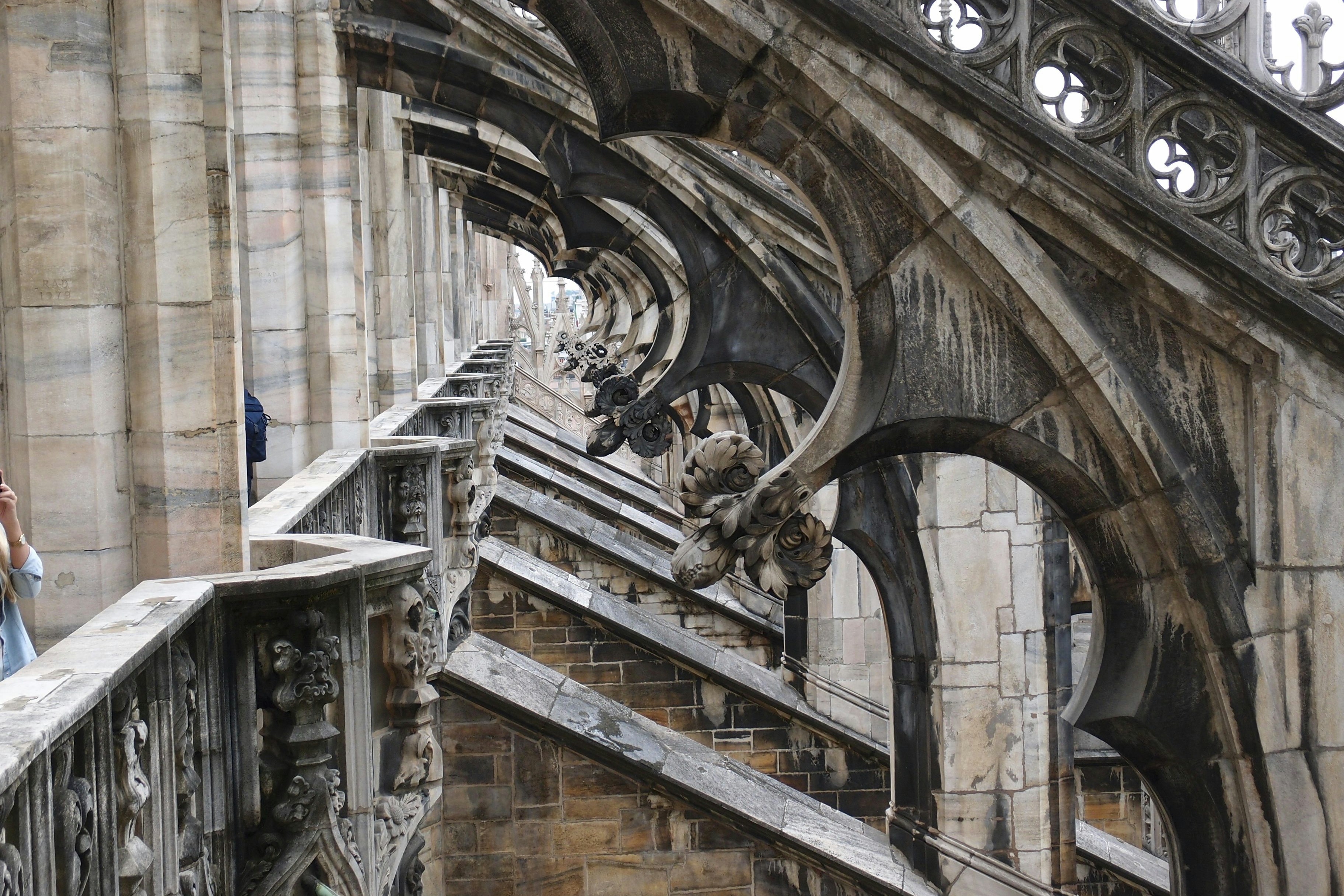 a woman standing on a balcony next to a building