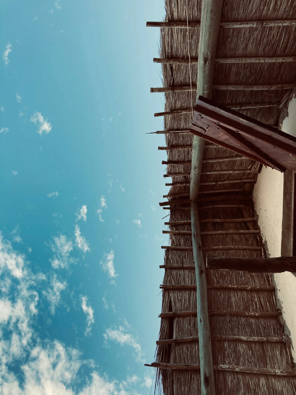 a thatched roof with a blue sky in the background