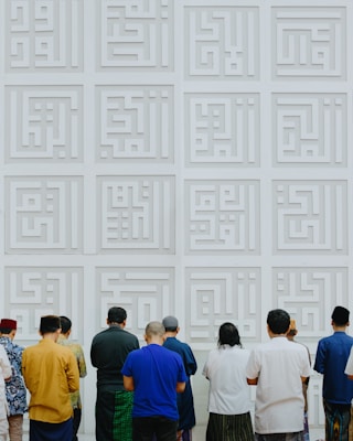 A group of people standing in front of a white wall