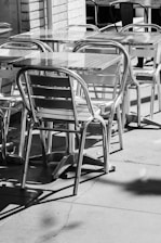 a black and white photo of tables and chairs
