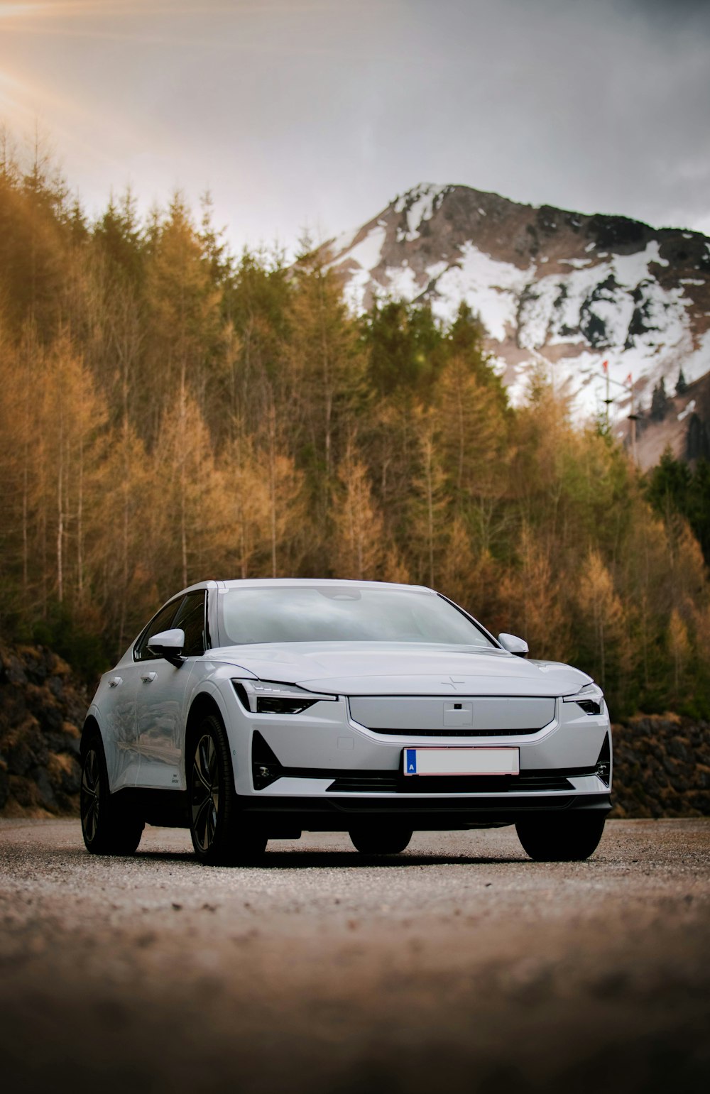 a white car parked in front of a mountain