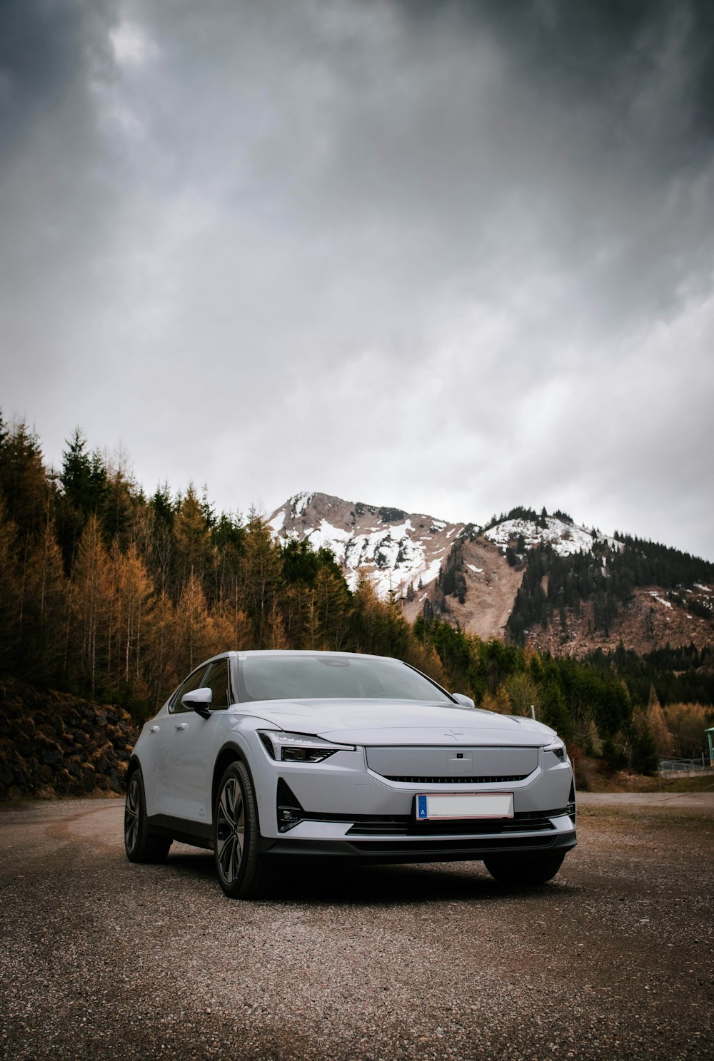 a car parked in a parking lot with a mountain in the background