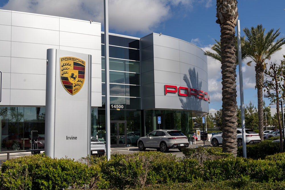 a porsche dealership with cars parked in front of it