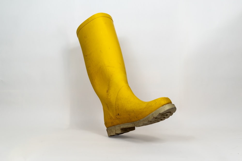 a pair of yellow rubber boots on a white background