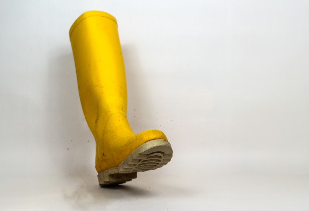 a pair of yellow rubber boots on a white background