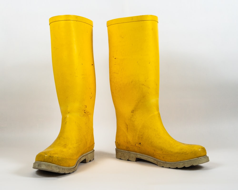 a pair of yellow rain boots on a white background