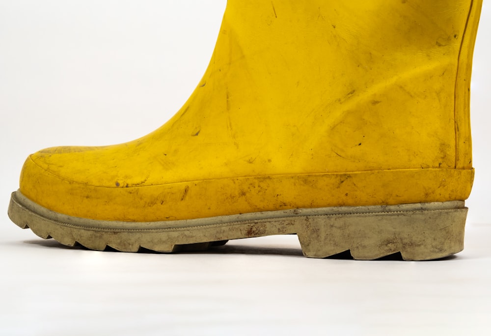 a pair of yellow rain boots on a white background