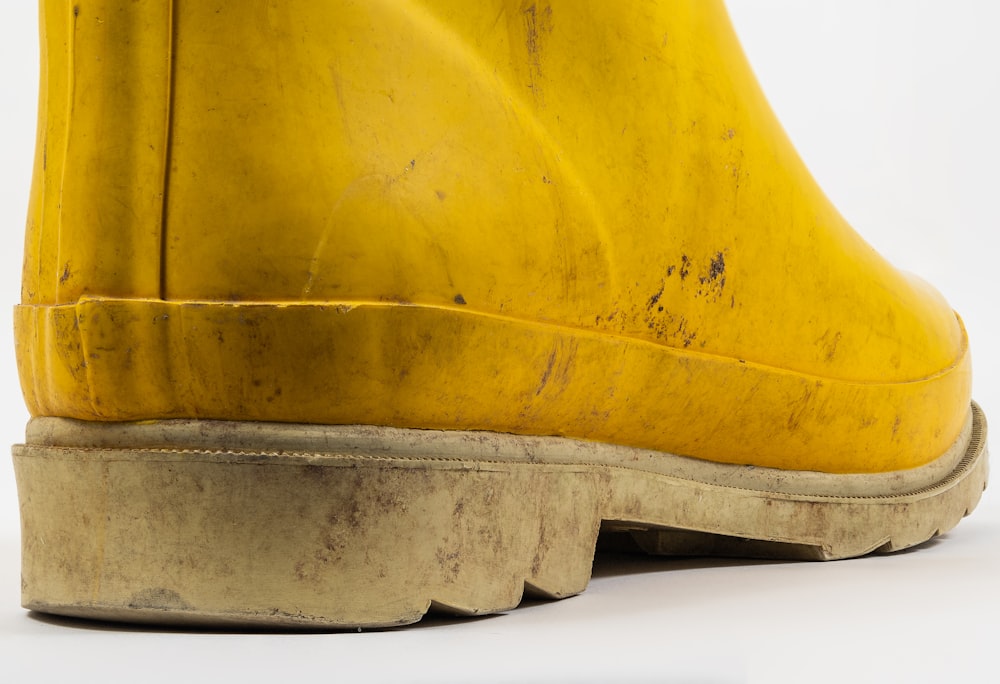 a close up of a yellow boot on a white background