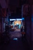a dark alley way with a neon sign
