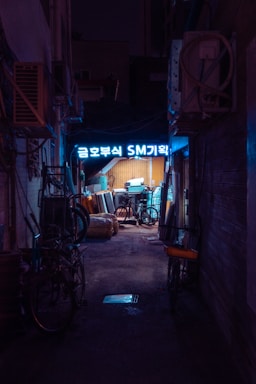a dark alley way with a neon sign