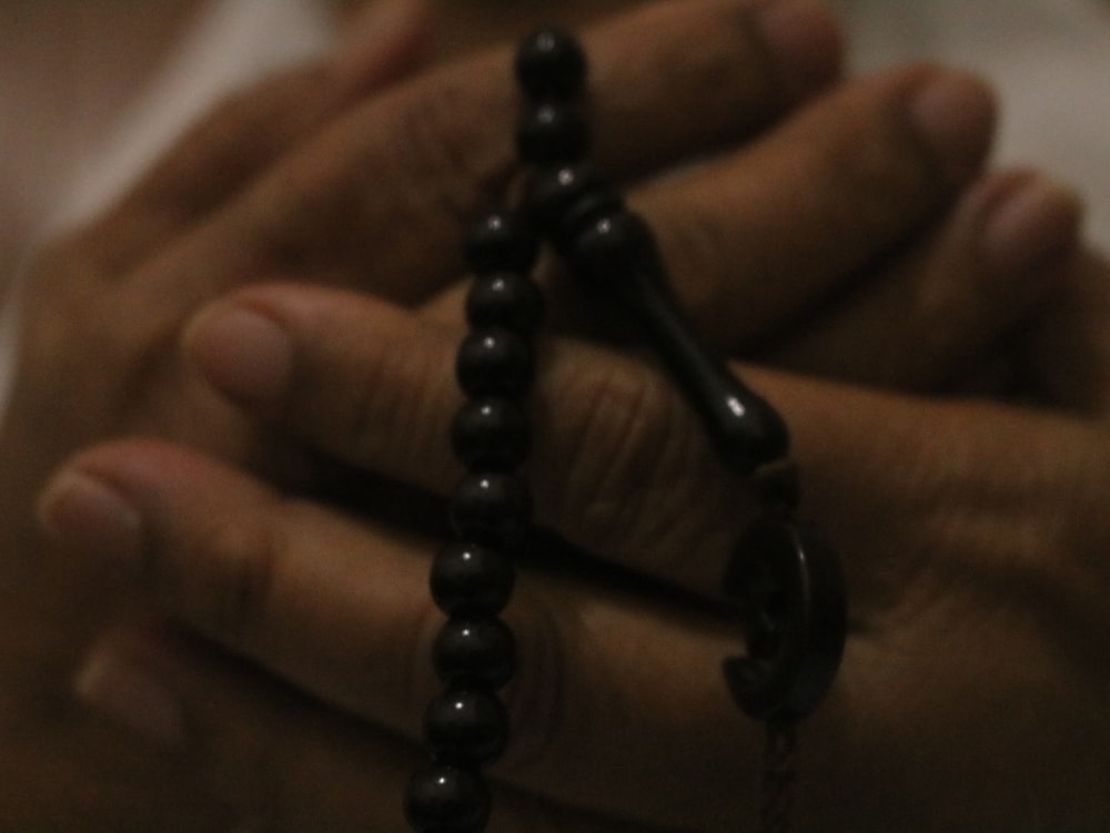 a close up of a person holding a rosary