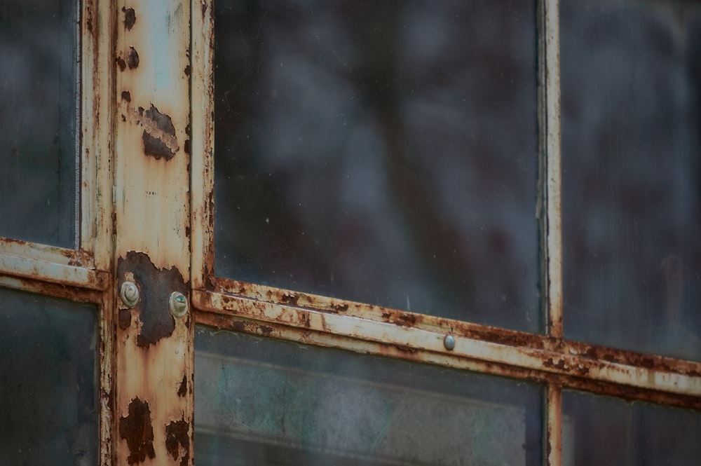 an old rusted metal door with glass