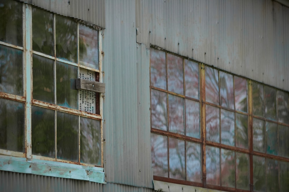 an old building with several windows and a rusted metal wall