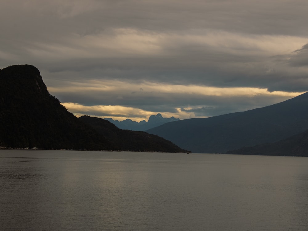 a large body of water with mountains in the background