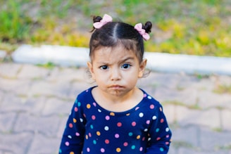 a little girl with a donut in her mouth