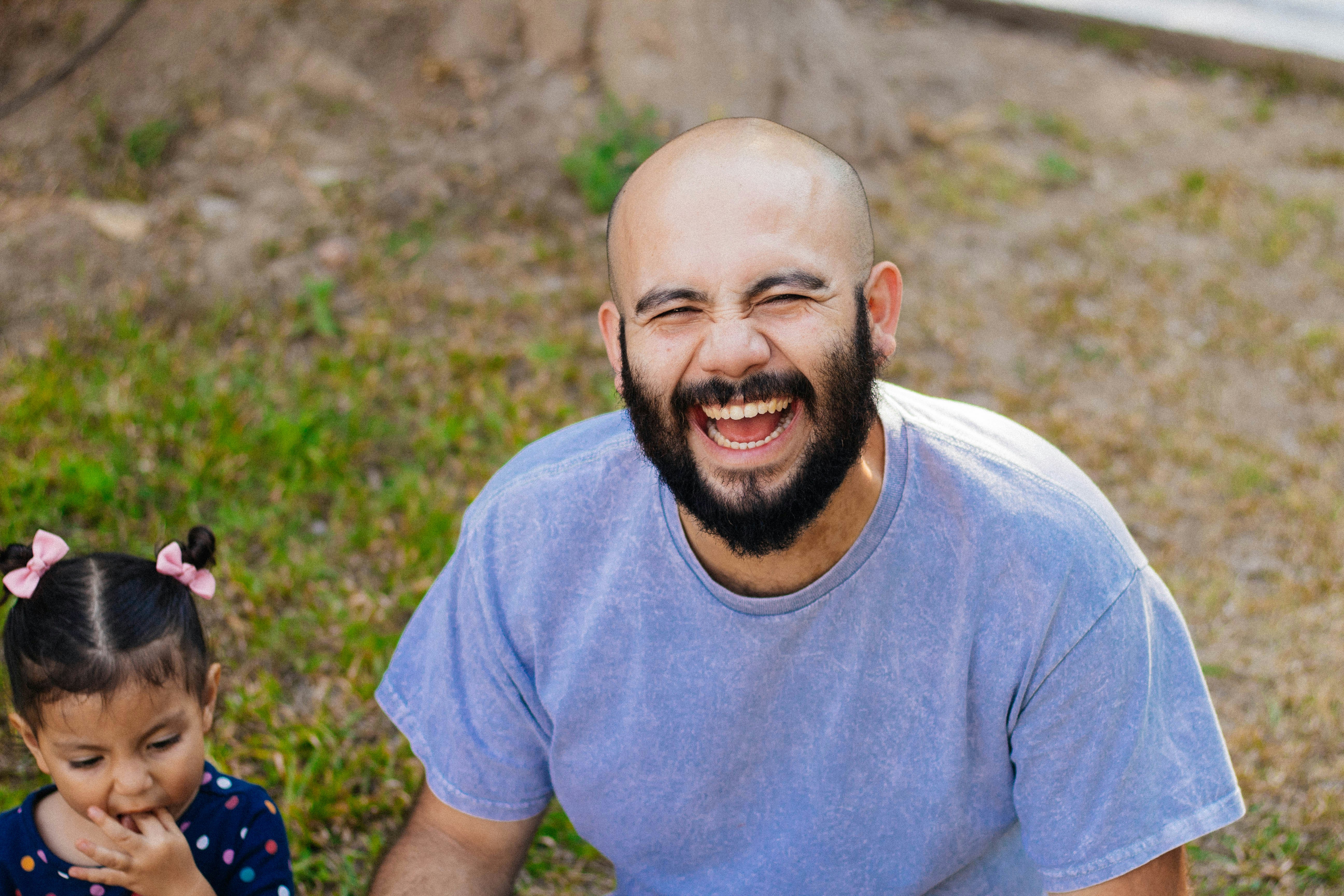 a man and a little girl sitting on the ground