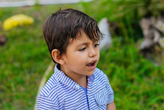 a young boy in a blue and white striped shirt
