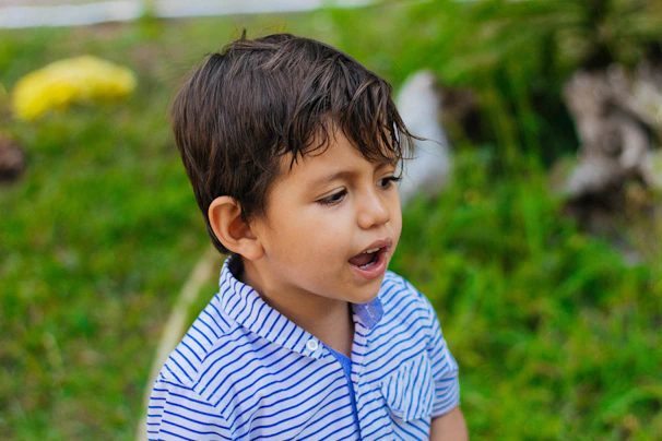 a young boy in a blue and white striped shirt