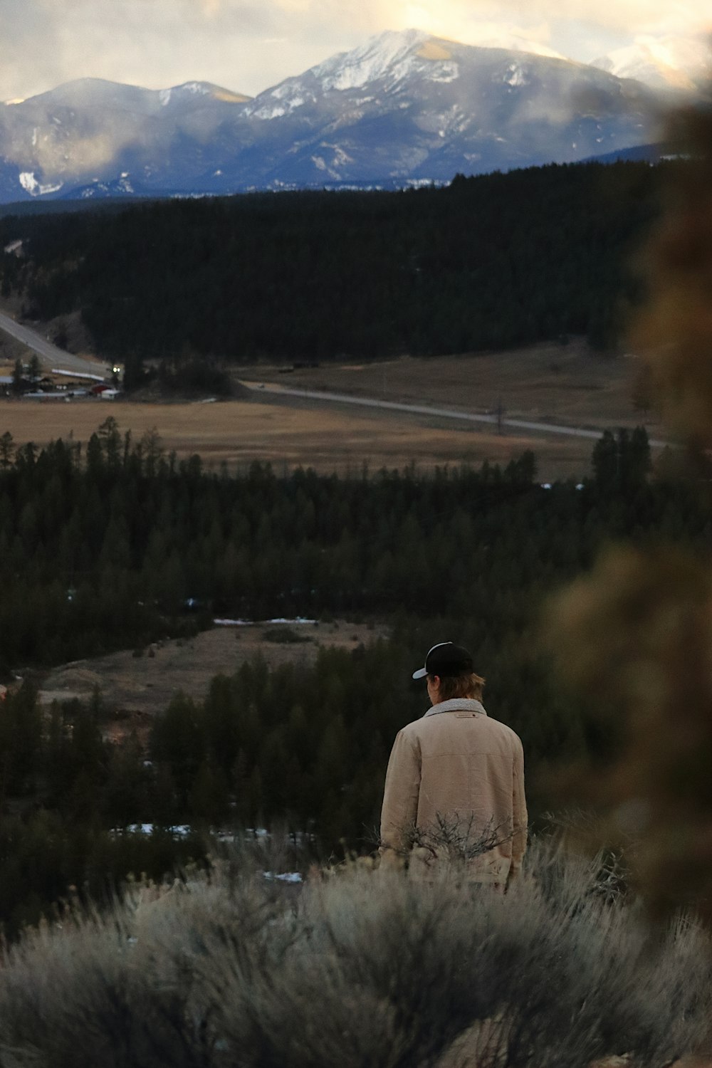 a man standing on top of a lush green hillside