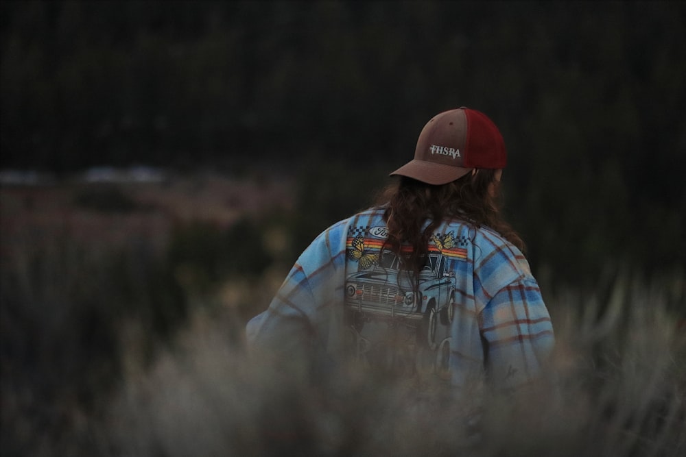 una persona parada en un campo con un sombrero puesto