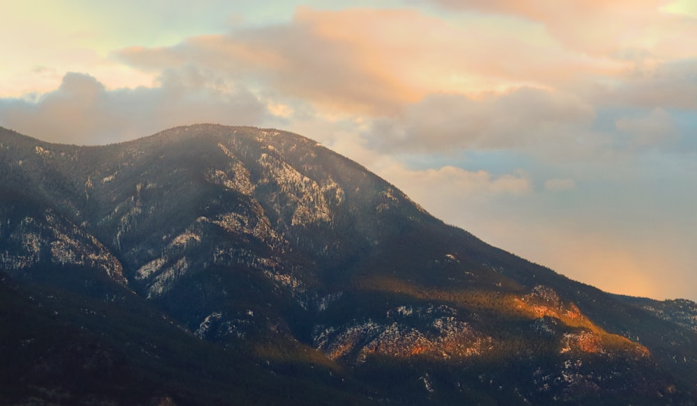 una montaña con algunas nubes en el cielo