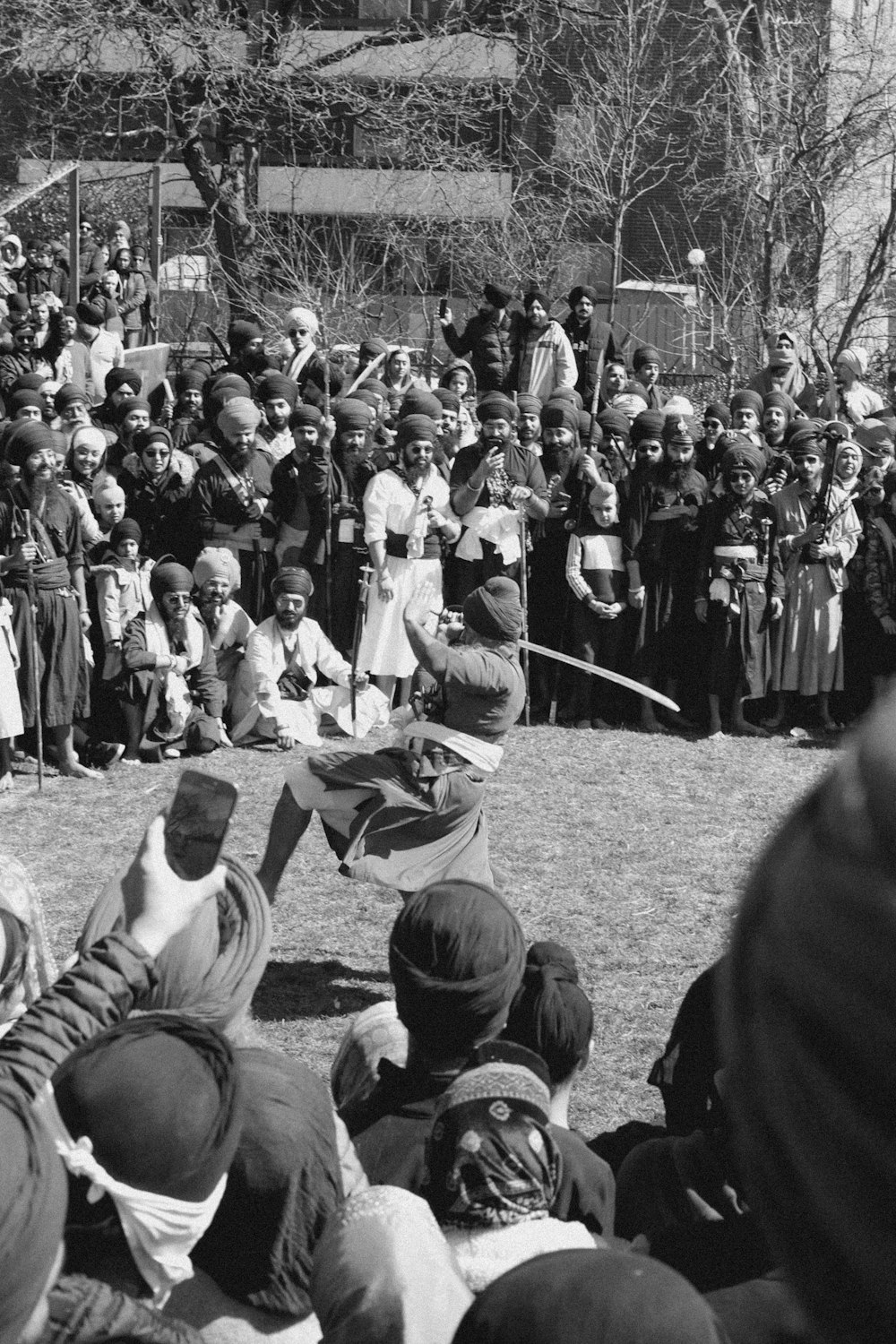 Un grupo de personas observando a un hombre con una espada
