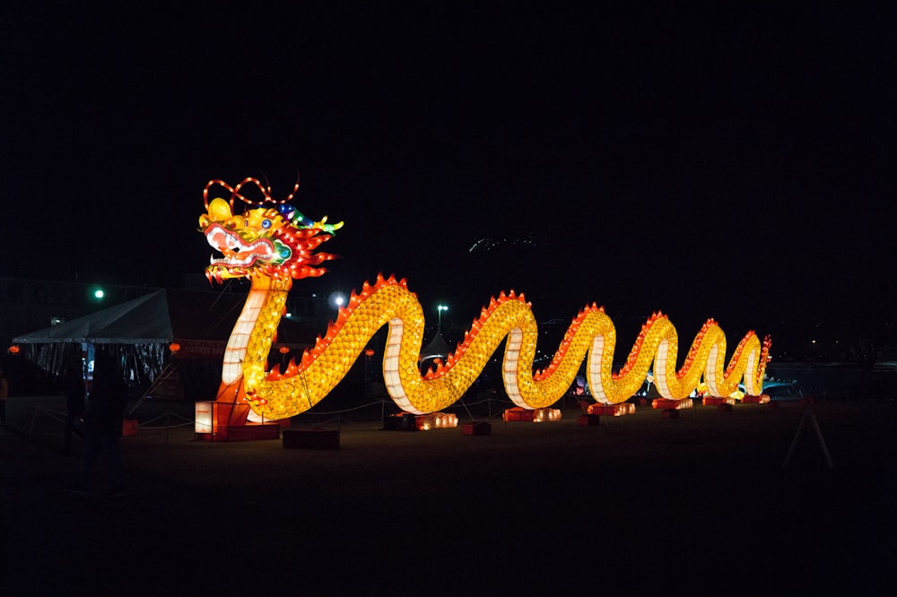 a lighted dragon sign in the dark at night