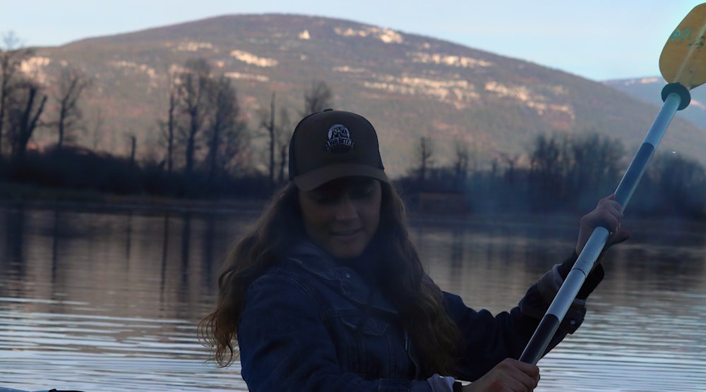 a woman paddles a canoe on a lake